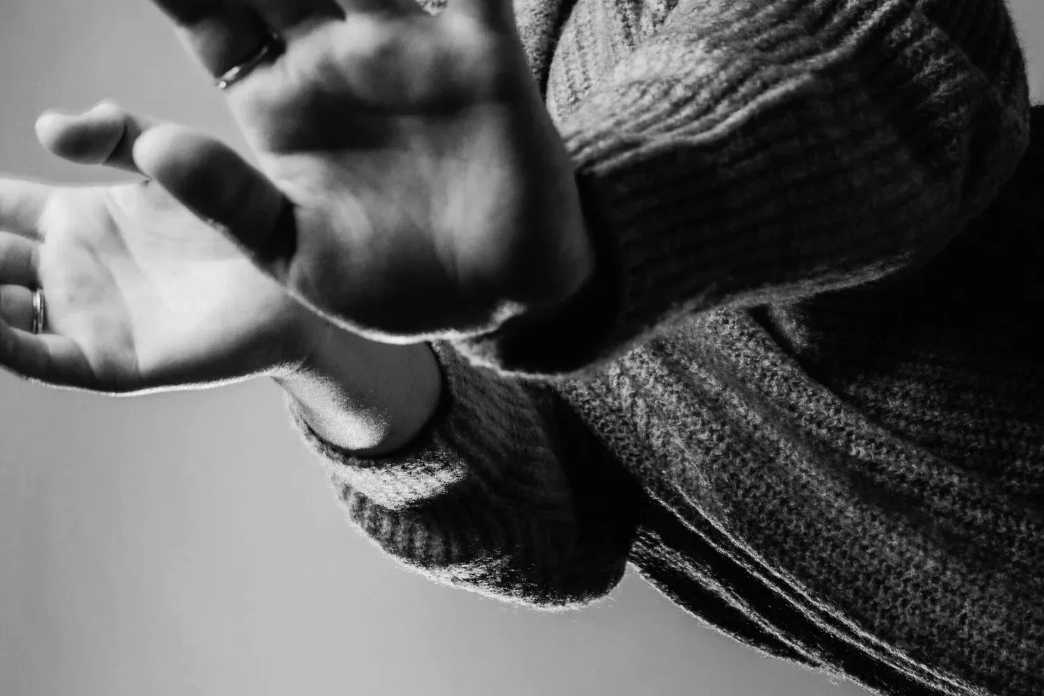 Black-and-white close-up of an open hand reaching forward
