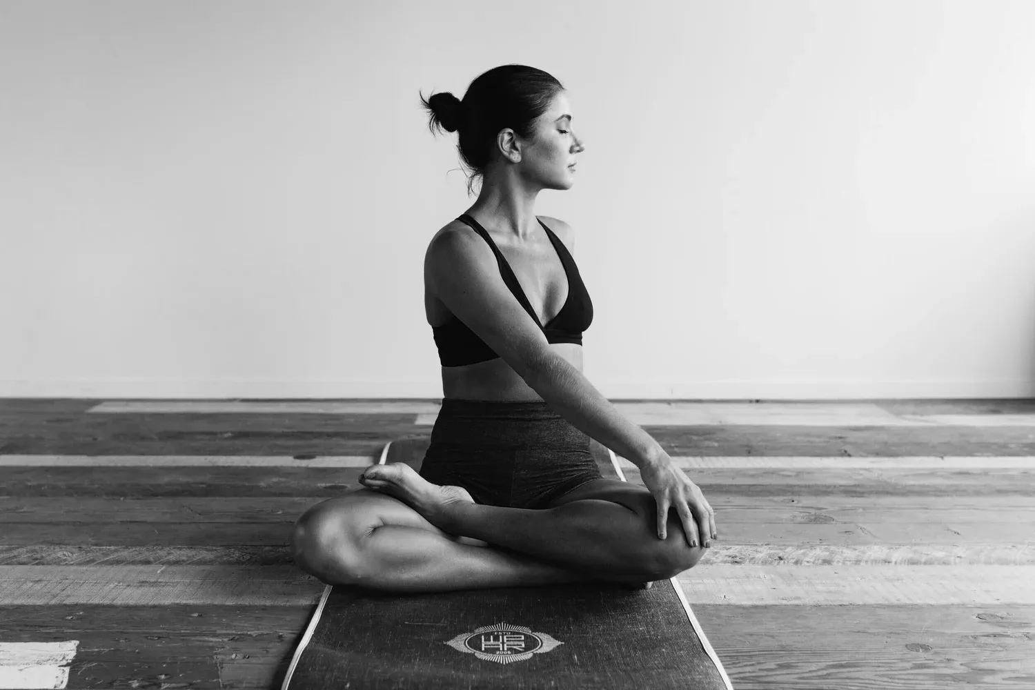 Woman kneeling on a mat in a bright, minimal room