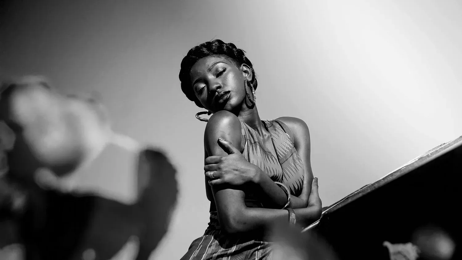 Black-and-white photo of a woman leaning back against a wall
