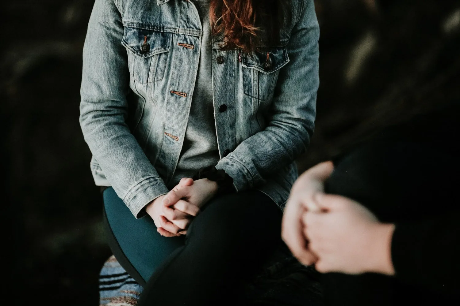 Two people seated side by side with hands clasped in their laps
