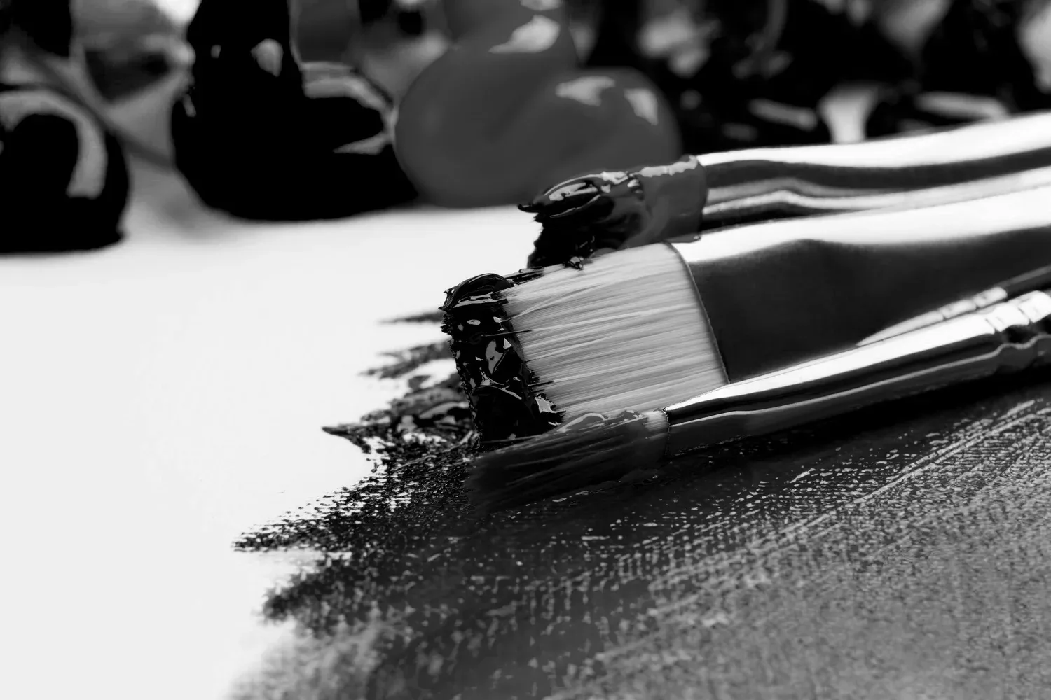 Black-and-white close-up of a paintbrush resting on a canvas