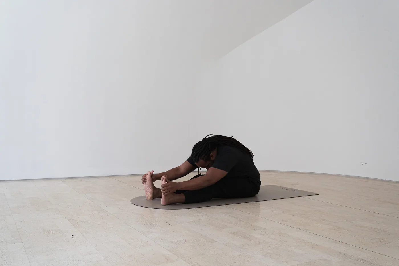 A person resting in a grounding posture on a mat